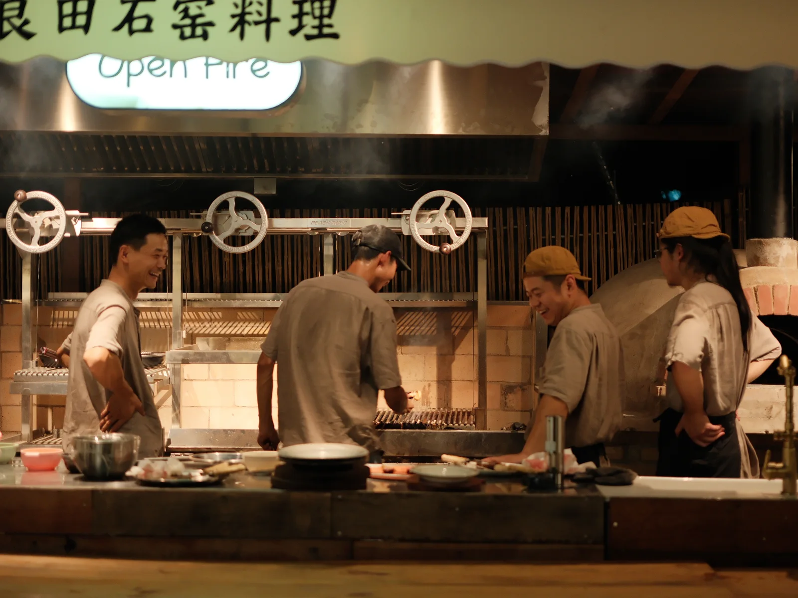 开放式厨房内多人在烤架前制作餐食